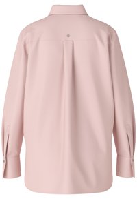 Chemise rose clair à manches longues avec un pli au dos, des poignets à boutons et un détail de logo subtil à la couture du col. Texture de tissu lisse.