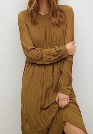 Robe à manches longues de couleur moutarde avec une texture plissée, présentant un col rond et une fente latérale à l'ourlet.