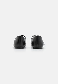 Černé kožené baleríny s kulatou špičkou a minimalistickým designem. Mají plochou podrážku a decentní branding na patě.
