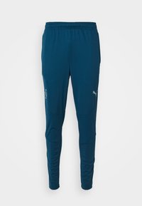 Donkerblauwe sportbroek van ademend materiaal, met een aansluitende pasvorm, elastische tailleband en reflecterend logo op de linker bovenbeen.