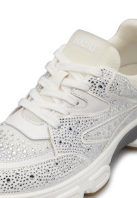 Sneakers bianchi con parte superiore in rete e pelle decorate con strass argentati, chiusura con lacci e suola testurizzata. Logo sul tallone.