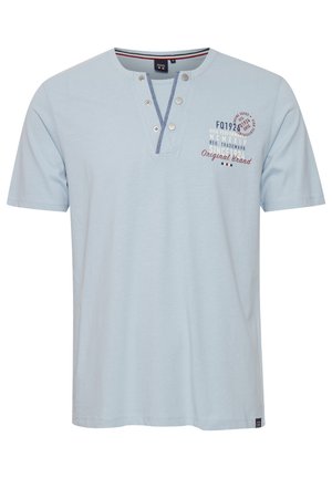 Svijetloplavi kratki rukav majica s Henley izrezom, s dva metalna gumba i tiskanim tekstualnim naglascima u tamnoplavoj i burgundijskoj boji. Mekani pamučni materijal.