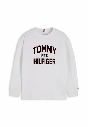 Hvid langærmet skjorte med sort "TOMMY NYC HILFIGER" tekst foran og lille Tommy Hilfiger-logo på venstre ærmekant.
