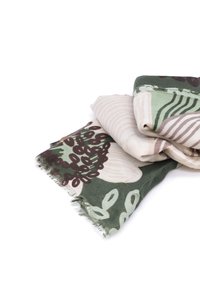 Sciarpa di cotone con un motivo botanico nei toni di verde, beige e marrone, con bordi frangiati e una texture morbida e leggera.