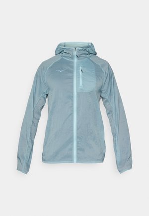 Veste légère bleu clair avec fermeture éclair à l'avant, capuche et poche poitrine zippée. Dotée d'un tissu texturé avec un logo sur la poitrine.