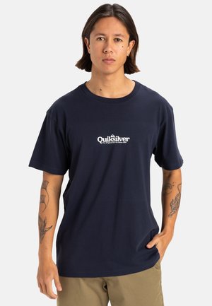 Camiseta de algodón azul marino con un logotipo blanco de Quiksilver en el centro. Diseño de mangas cortas y cuello redondo. Textura suave.