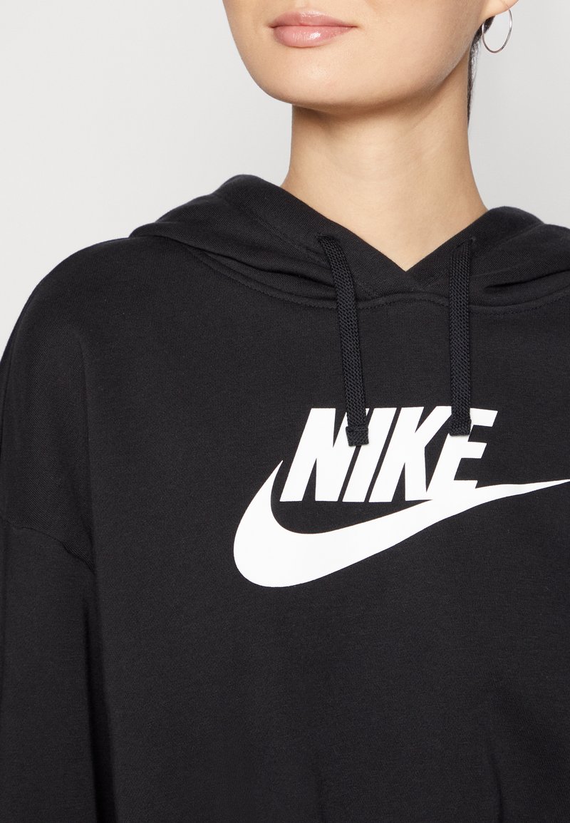 Sudadera con capucha negra hecha de tejido suave, con un gran logo de Nike en blanco. Incluye cordones en la capucha y un corte holgado.