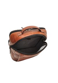 Bruine leren tas met een gestructureerde vorm, ritsluiting en een gestreepte zwart-witte binnenkant. Voorzien van een handvat aan de bovenkant voor het dragen.