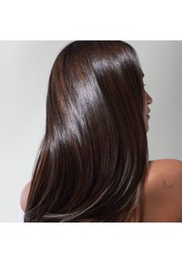 Cheveux longs, brillants et brun foncé avec des reflets subtils, texture lisse, dévalant sur une épaule ; petit tatouage en croissant visible sur la peau.