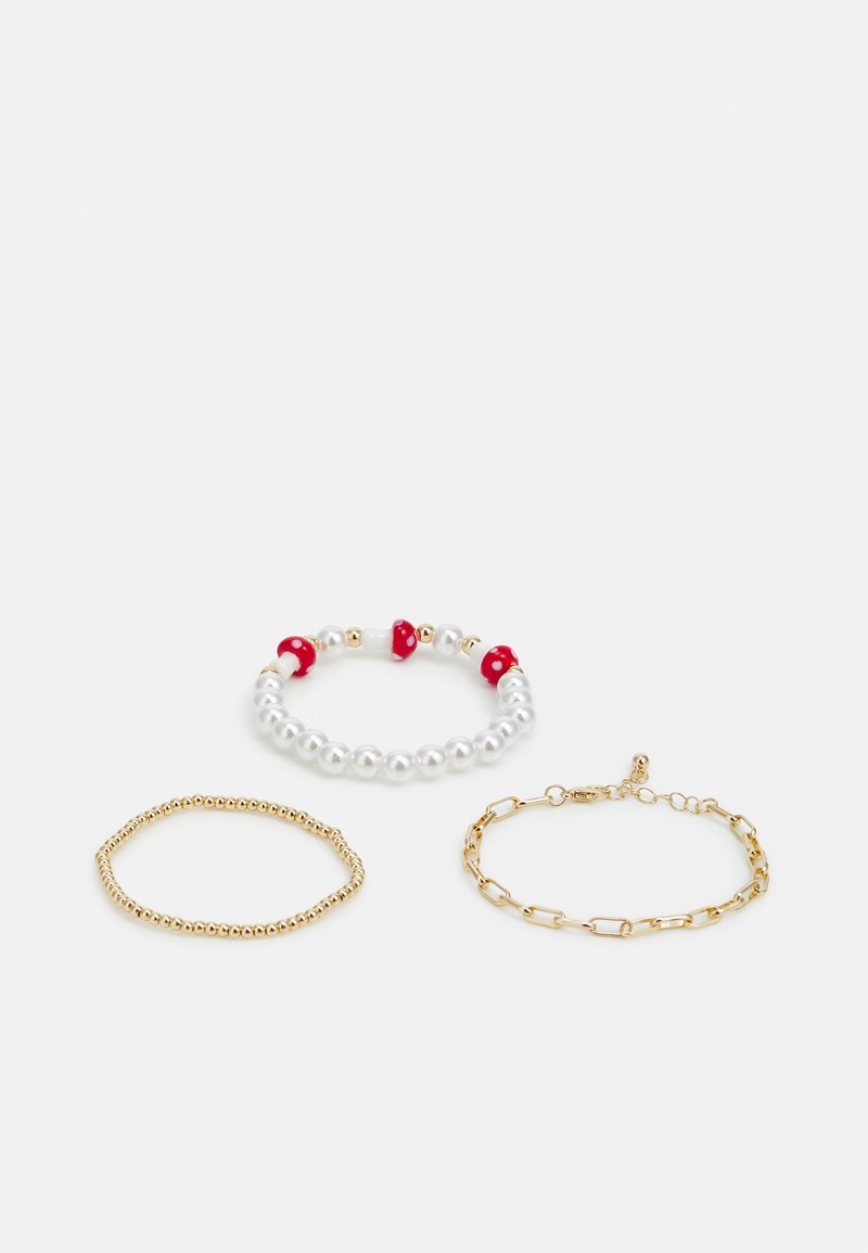 TrêsPulseiras: uma com pérolas brancas e contas vermelhas, uma fita fina de contas douradas, e uma pulseira de corrente dourada com fecho.