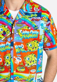 Erineva lühikeste varrukate sart, millel on julge SpongeBob SquarePants trükk, sisaldades mitmesuguseid elavaid värve ja mängulisi graafikaid.