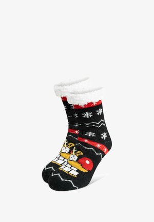 Schwarze Socken mit einem flauschigen weißen Bündchen, verziert mit einem festlichen Muster aus Rentieren und Schneeflocken in roten, weißen und gelben Strickmustern.