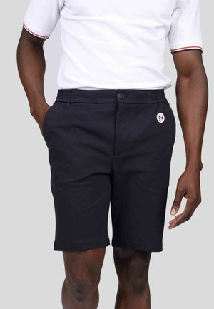 Shorts marins en tissu lisse, conçus avec une taille élastique et des poches latérales, arborant un petit patch logo blanc.