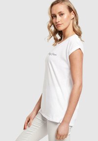 Hvit bomulls t-skjorte med rullet korterm, med svart tekst "Pretty Flawless" på forsiden. Glatt tekstur, avslappet passform.