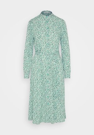 Világoszöld gombos ruha, levélmintával, hosszú ujjakkal, övvel a derékon és egyenes szabással, kontrasztos mandzsettákkal.