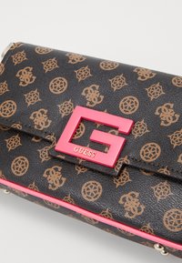Portefeuille à motif noir avec logos marron, arborant un logo "G" rose proéminent et une bordure rose, fabriqué en matériau synthétique texturé.