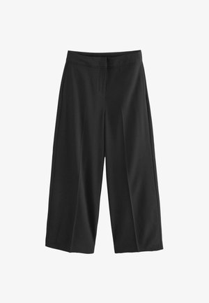 Melna platpēdu bikses ar gludu tekstūru, ar bārkstainu priekšpusi un pielāgotu jostasvietu. Iezīmējas ar īsu garumu un bez redzamām kabatām.