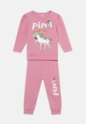 Ensemble rose à manches longues et pantalon avec une fille de dessin animé chevauchant un cheval blanc et le mot "Pippi" imprimé sur les deux pièces.