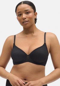 Sujetador negro con un diseño estructurado, adornos de encaje, textura de puntos, tirantes ajustables y un acabado suave.