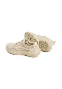 Valkoiset urheilukengät, joissa on strukturoitu ja sileä yhdistelmäpinta, paksu kumipohja ja takana vetotuki helppoa pukemista varten.