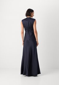 Navy satin maxi-mekko, jossa on olkaimeton malli, tiukka yläosa ja levenevä hame. Ominaisuuksiin kuuluu hienovarainen takasauma ja sileä rakenne.