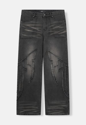Zwarte spijkerbroek met losse pasvorm, voorzien van distressed details en unieke uitsnijdingen op de benen. Knopenluiting en model met vijf zakken.