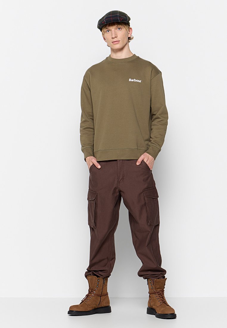 Felpa verde oliva con logo bianco "Barbour", abbinata a pantaloni cargo marroni con grandi tasche e stivali marroni con lacci.