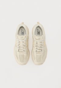 Scarpe da corsa beige in materiale mesh e sintetico. Punta arrotondata, colletto imbottito e suola in gomma testurizzata. Lacci e logo sulla linguetta.