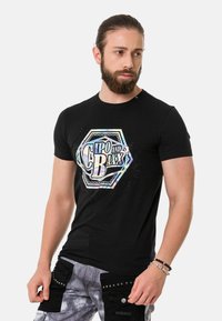 Schwarzes T-Shirt mit kurzen Ärmeln, das ein mehrfarbiges, schillerndes Logo 'Cipo and Baxx' in hexagonaler Form zeigt. Glatte Textur.