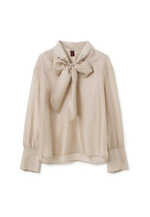 Blouse beige en tissu lisse, dotée d'un grand col nœud, de manches longues avec des poignets froncés, et d'une coupe décontractée.