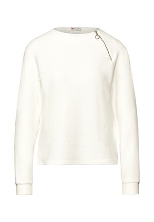 Pitkähihaisessa valkoisessa teksturoidussa neuleessa on pyöreä pääntie ja vinottain oleva hopeinen vetoketjydet lähellä oikeaa olkapäätä.