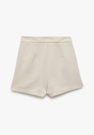 Shorts beiges en tissu doux, dotés d'une taille lisse, de deux poches latérales et d'une coupe droite avec des bords ourlés.