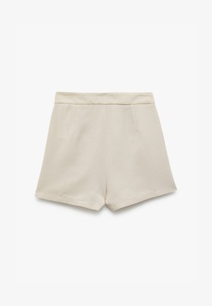Shorts beiges en tissu doux, dotés d'une taille lisse, de deux poches latérales et d'une coupe droite avec des bords ourlés.