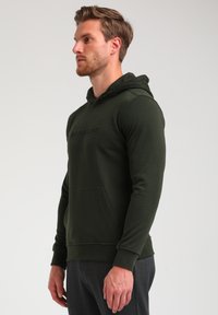 Sudadera verde de tejido suave con un bolsillo frontal, detalle de logo texturizado en el pecho y capucha ajustable con cordón.