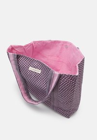 Duża torba na płótno z różowym wnętrzem, z teksturowanym geometrycznym wzorem w kolorze fioletowym i czarnym oraz metką "SUMMERY" w środku.