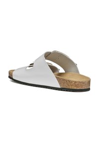 Sandal in pelle bianca a slip-on con design a intaglia, plantare in sughero e suola in gomma nera texturizzata. Parte superiore liscia con una forma della punta arrotondata.