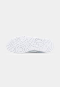 Semelle extérieure de basket Lacoste présentant un design en caoutchouc blanc texturé avec des motifs de traction circulaires et linéaires. Logo embossé près du talon.