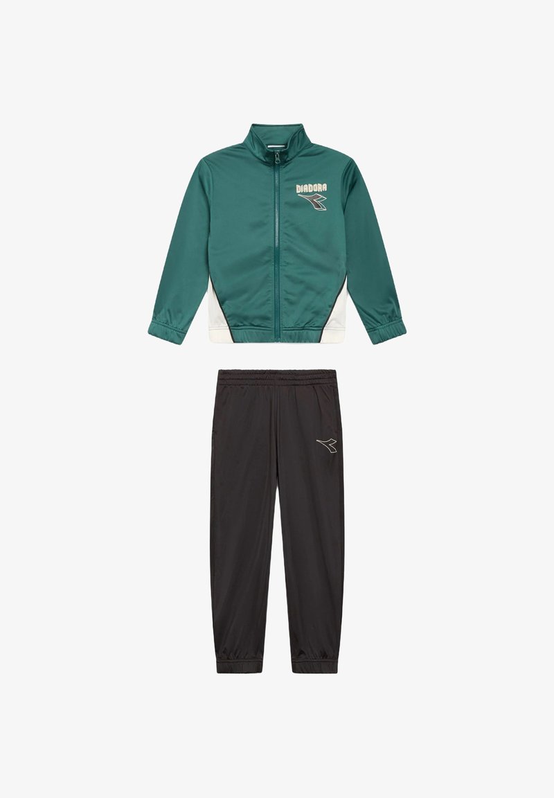 Giacca a zip verde e bianca con logo abbinata a pantaloni da jogging neri con vita elastica, caratterizzati da un piccolo logo sulla coscia.