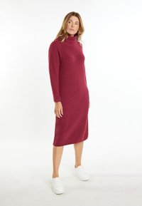Vaahto burgundy-kjole med høy hals, lange ermer, midt-lår lengde og et teksturert mønster, kombinert med hvite sneakers.