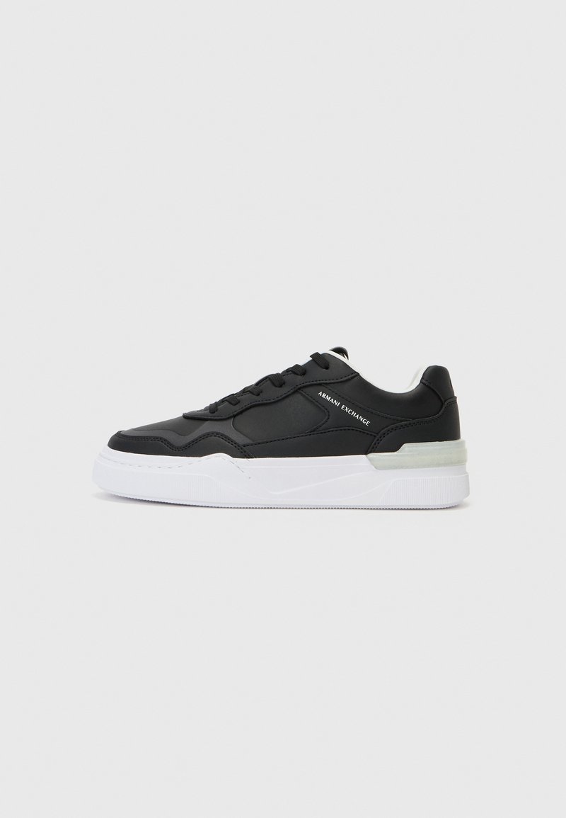 Svart sneakers med en glatt læroverdel, snøring, hvit såle med teksturert finish og subtil merking på siden.