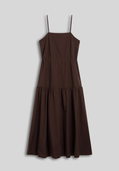 Robe midi marron sans manches avec fines bretelles, taille cintrée et jupe froncée sur un fond gris.