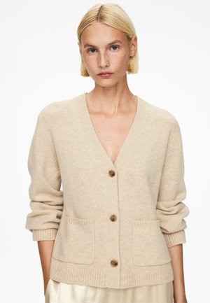 Beige knit cardigan with a V-neck, front buttons, two pockets, and ribbed cuff and hem detailing, made of soft material.