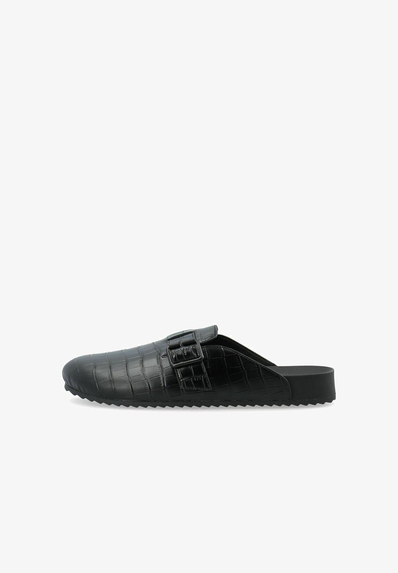 Zwarte instapschoenen met een gestructureerd krokodillenpatroon, een zijgesp detail en een zachte, gebogen silhouet met een platte zool.