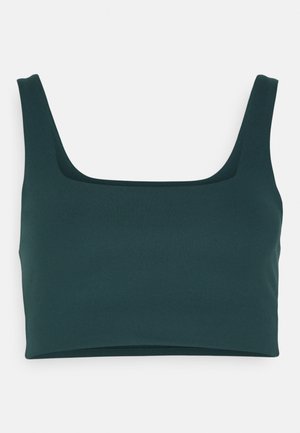 Tmavozelený skrátený top s kocourovým výstrihom, vyrobený z hladkej látky. Má široké ramienka a priliehavý strih.