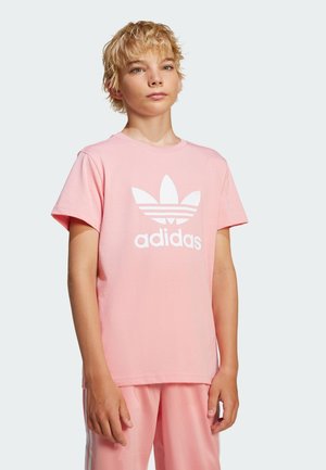 Lyserød bomulds T-shirt med korte ærmer, der har en stor hvid Adidas-logo og et tre-bladet grafisk design på forsiden.
