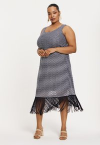 Kleid mit Navy- und Weißmuster, rundem Ausschnitt, ärmellosem Design und Fransen-Saum. Tragen mit beige block-absatz Sandalen.