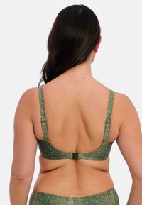 Groene beha met een gestructureerd slangenprintpatroon, verstelbare bandjes en een haaksluiting op de rug. Glad materiaal met minimale naden.