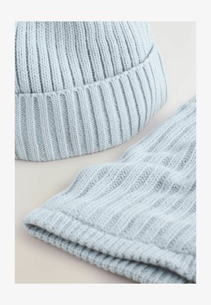 Svijetloplava pletena kapa sa rebrastim uzorkom i preklopom, u kombinaciji s odgovarajućim rebrastim šalom iste boje i teksture.