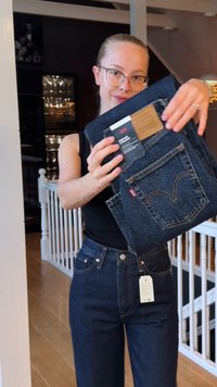 Mørkeblå denimjeans med høy midje, gyldne sømmer og et karakteristisk baklommendesign. Inkluderer en merkelapp på linningen.