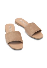 Sandale din suede bej, cu talpă plată și curea lată în partea de sus, având un logo alb pe interior. Design simplu, cu vârf deschis.
